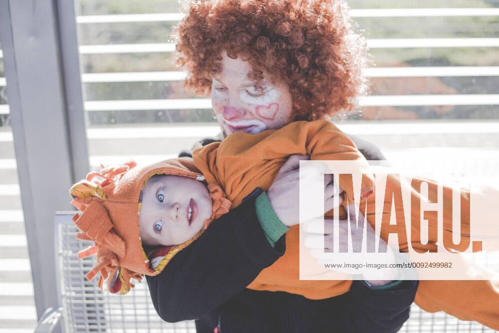 Man dressed up as a clown and little boy dressed up as lion baby at carnival model released Symbolfoto IHF00086