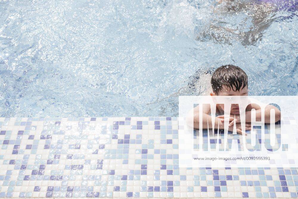 Little boy relaxing at poolside model released Symbolfoto LJF00033