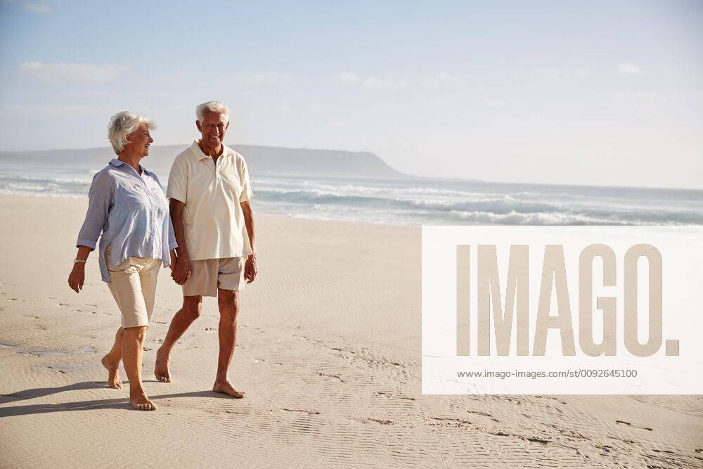 Senior Retired Couple Walking Along Beach Hand In Hand Together ,model released, Symbolfoto
