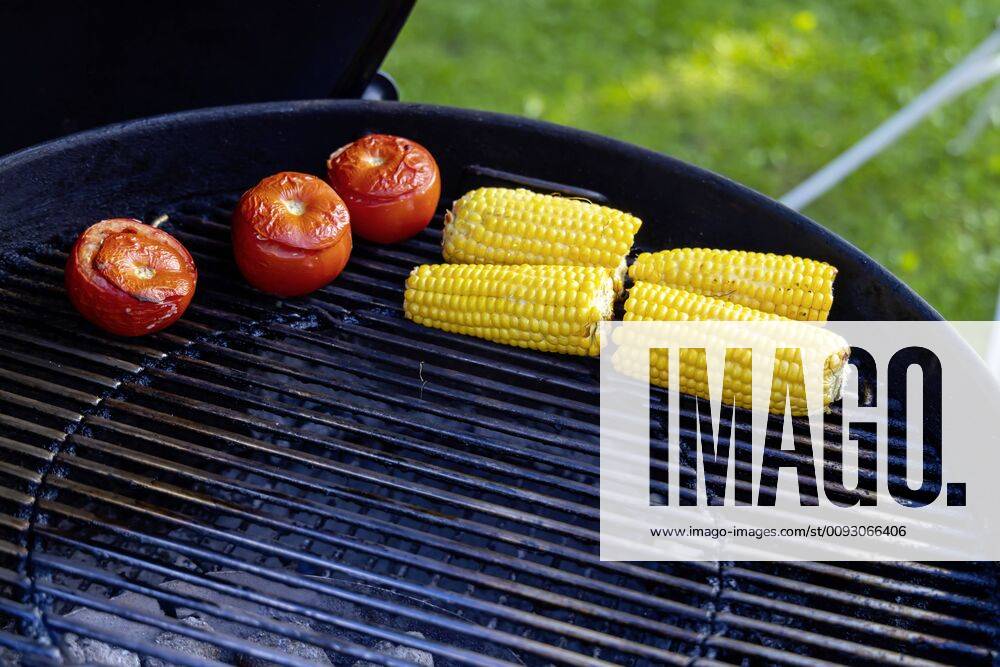 DEU, Deutschland, Münsingen, Baden-Württemberg, 24.08.2019: Grillfest im Garten. Auf dem Rost liegen Tomaten und Mais.