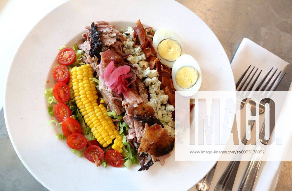 A Dewey Cobb Salad made with Barbecue Pork Shoulder, corn, applewood bacon, tomatoes, hard boiled egg, blue cheese, and poblano buttermilk vinaigrette dressing is offered at the Dewey Beach Restaurant in Pass-a-Grille. St. Pete Beach USA - ZUMAs70_ 20190828_zan_s70_027