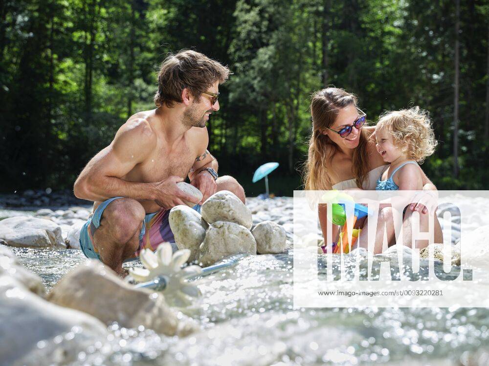 Family with daughter playing in a mountain stream model released Symbolfoto CVF01367