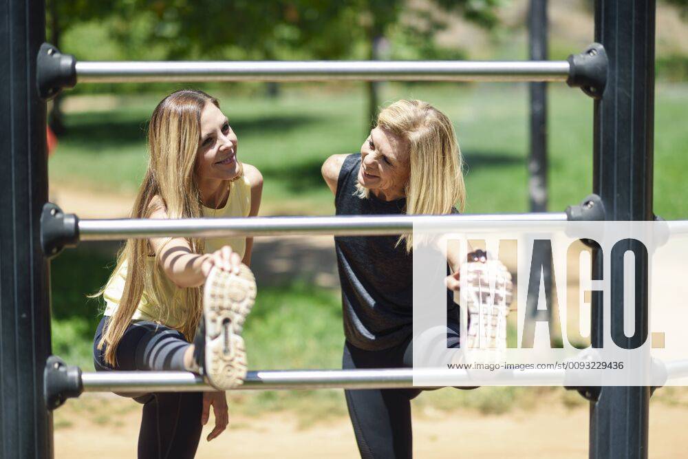 Mature woman exercising with her daughter in a park model released Symbolfoto JSMF01158