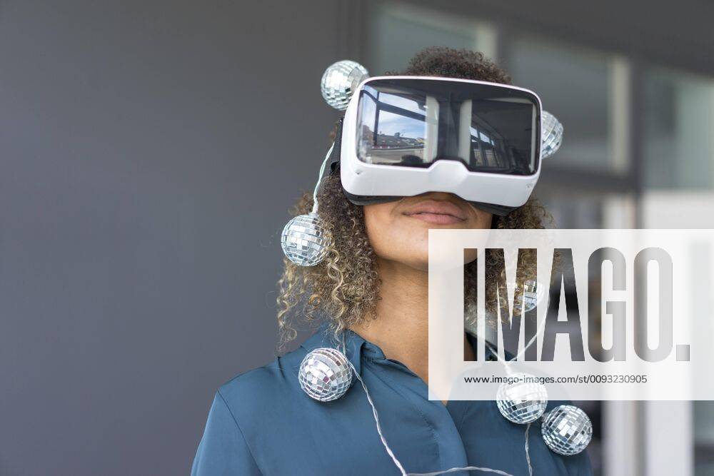 Creative Highlights Symbolfoto Smiling young woman with chain of lights using Virtual Reality Glasses model released Symbolfoto property released MOEF02379