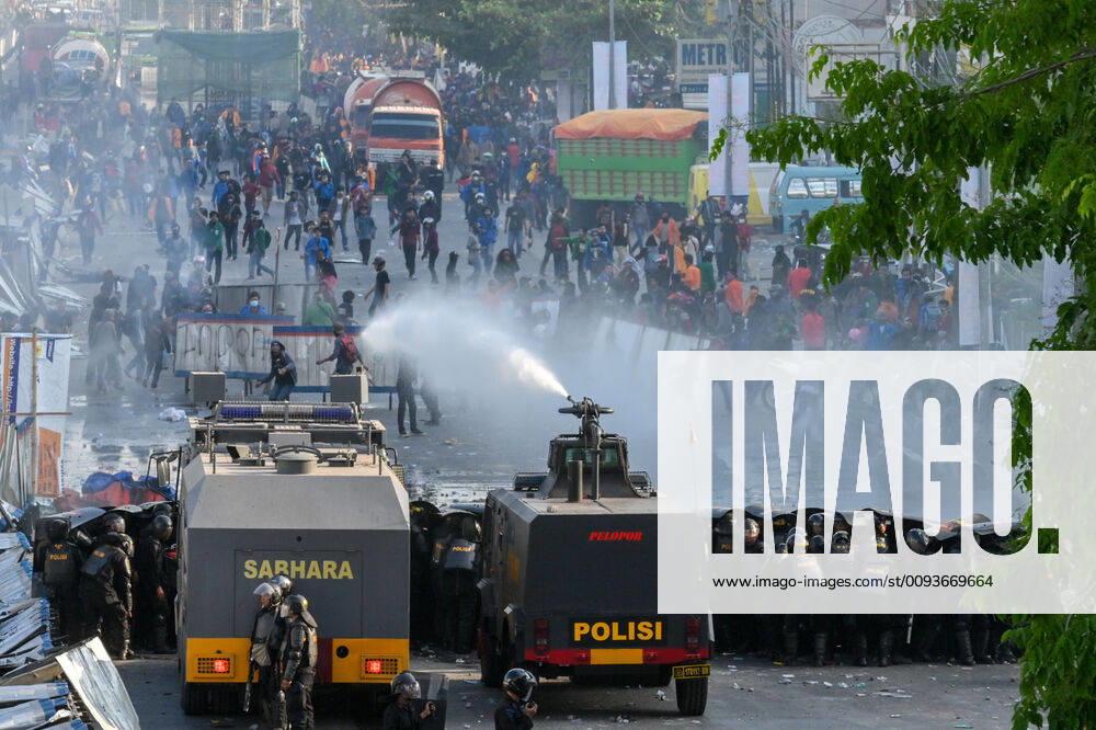 Riot police water cannons firing into protesters during the demonstration..Police fired tear gas and water cannons to disperse protesters as thousands demonstrated over plans proposed by the government to change the criminal code laws and weaken anti-corruption institutions. Makassar Indonesia - ZUMAs197 20190924_zaa_s197_001