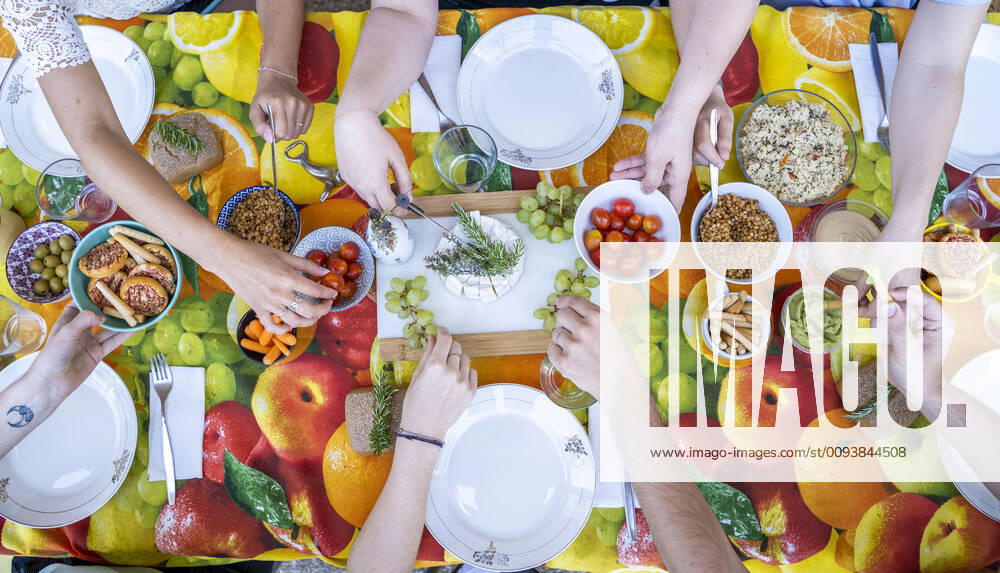 Healthy vegetarian meal on top of colorful table with friends, from above model released Symbolfoto AFVF03970