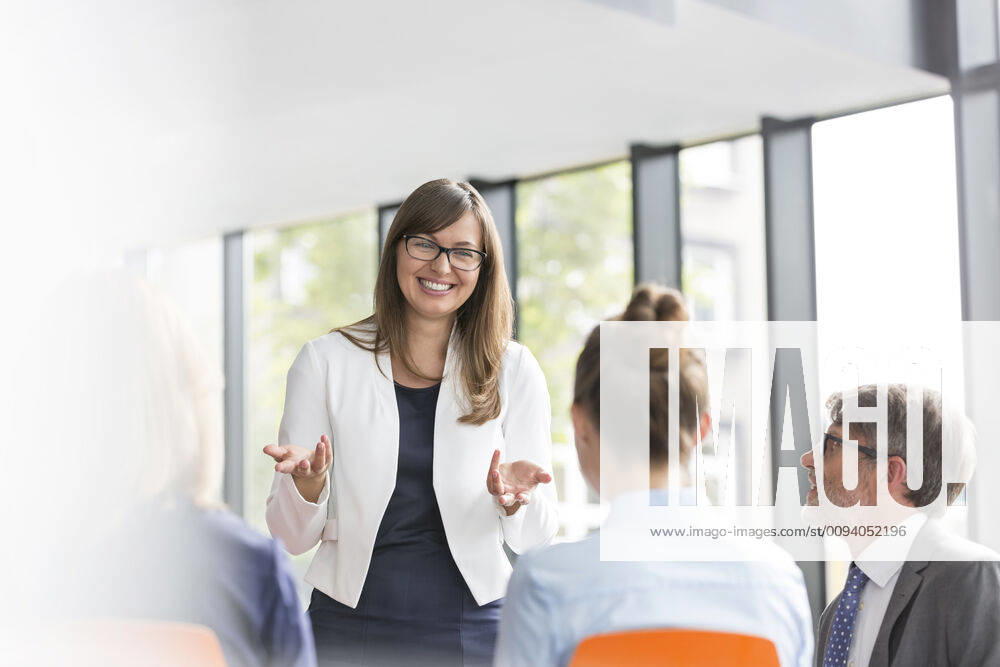 Smiling businesswoman planning strategy with colleagues during meeting at office,model released, Symbolfoto INH_19064_12540