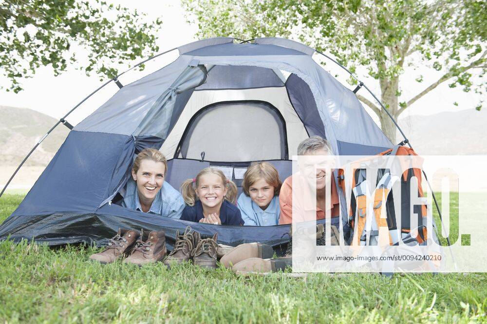 Family of four smiling from a tent,model released, Symbolfoto,property released 03B86835