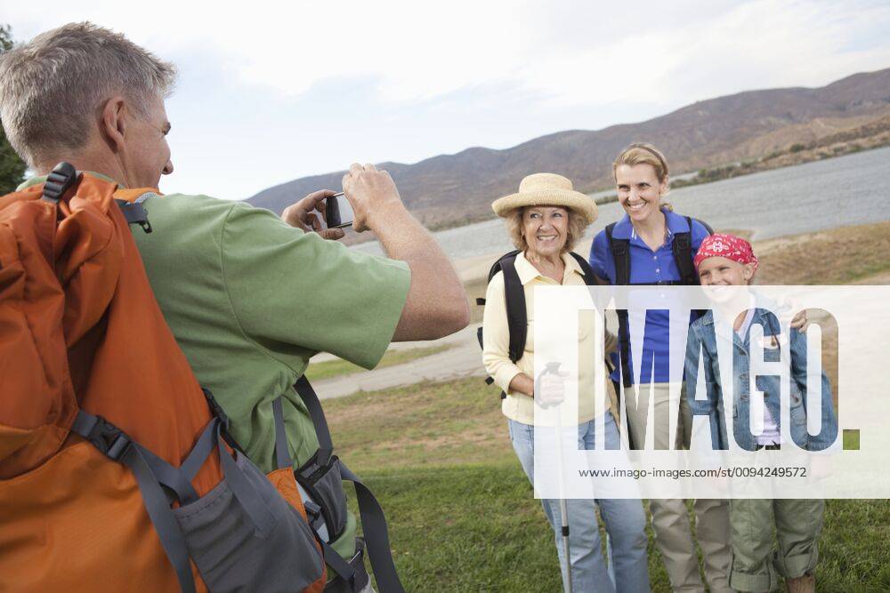 Man photographhs a mother daughter and grand-daughter at lakeside together,model released, Symbolfoto,property released 03B94418