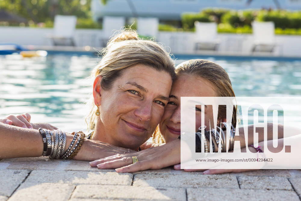 Mother and her 13 year old daughter in pool smiling mother and her 13 year old daughter in pool smiling 58787