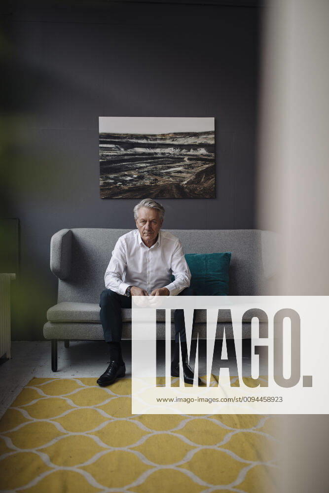 Portrait of senior businessman sitting on a couch model released Symbolfoto property released GUSF02569
