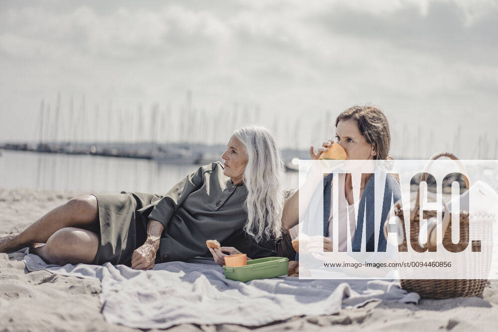 Mother and daughter having a picnic on the beach model released Symbolfoto JOSF03694