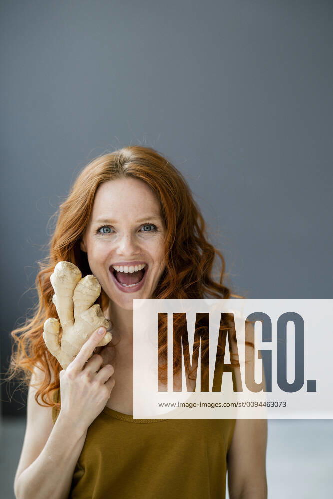 Portrait of excited redheaded woman with ginger root model released Symbolfoto property released KNSF06533
