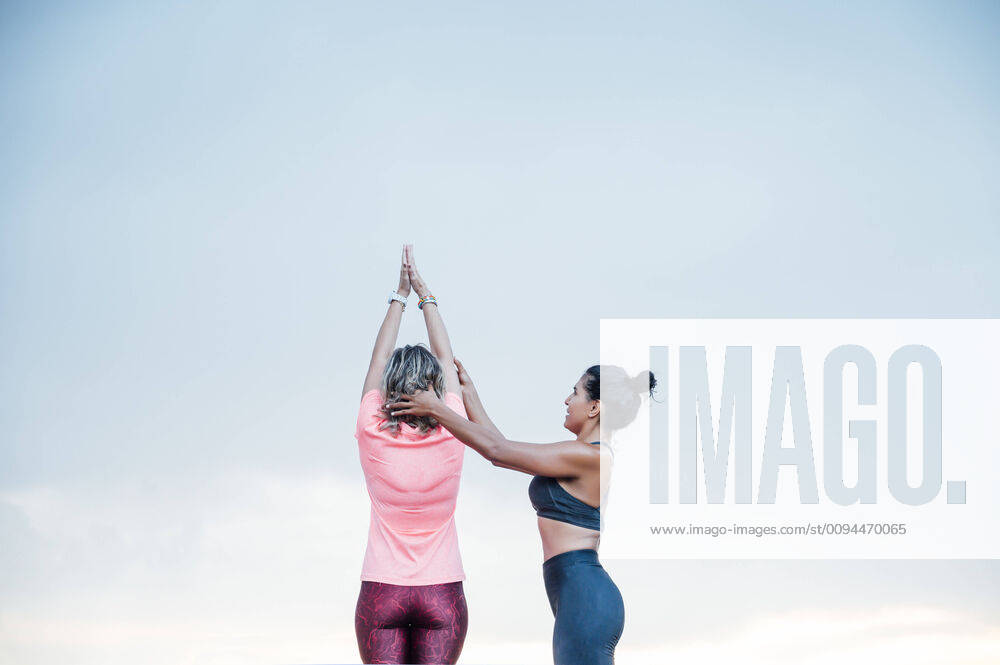 Woman teaching yoga to senior woman model released Symbolfoto OCMF00732