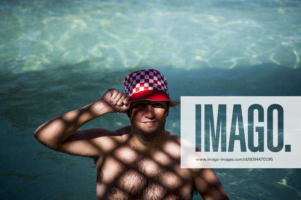 IMAGO Creative, Jahreszeit Sommer, Hitze IMAGO Creative, Sommer, Schatten-Plätze bei Hitze Portrait of overweight man with hat in pool in shady area model released Symbolfoto OCMF00779