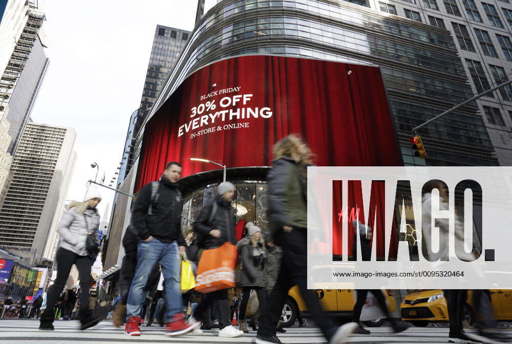 Shoppers holding bags from retail stores walk by discount Black Friday signs in Times Square on Black Friday in New York City on Friday, November 29, 2019. For over a decade, Black Friday has traditionally been the official start to the busy buying binge sandwiched between Thanksgiving and Christmas. NYP20191129114 JOHNxANGELILLO