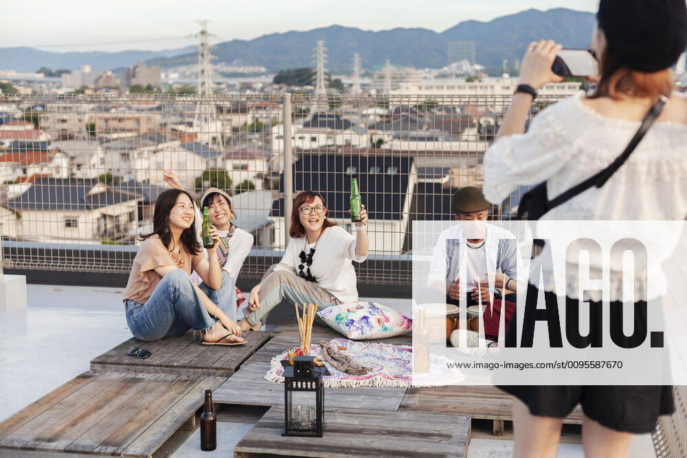 IMAGO Kreativ: Urbane Kultur - Sommer auf den Dächern Smiling group of young Japanese men and women on a rooftop in an urban setting. Smiling group of young Japanese men and women on a rooftop in an urban setting. 60077