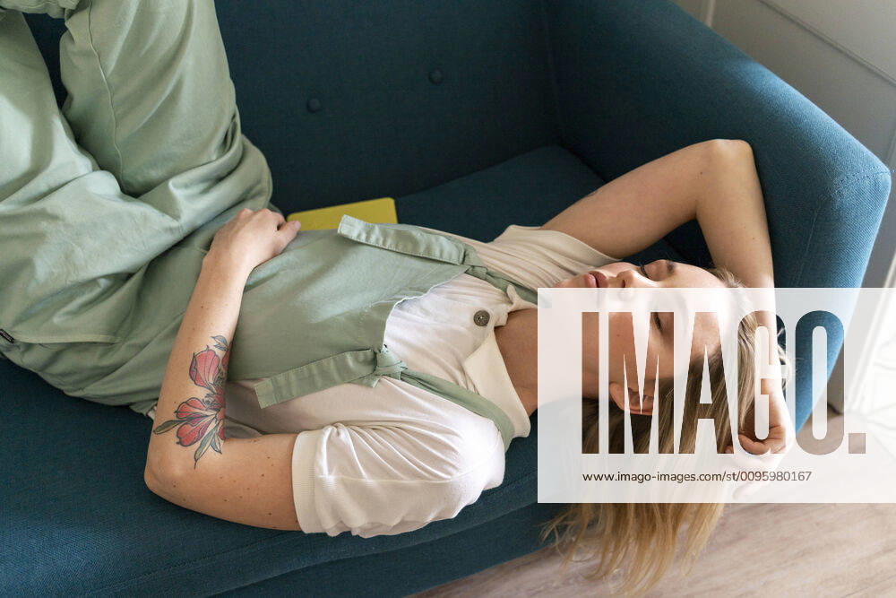 Portrait of young woman lying on couch with closed eyes model released Symbolfoto property released AFVF04484