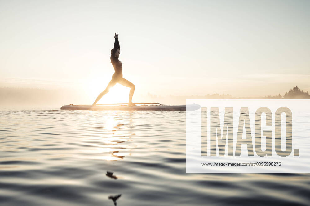 IMAGO Creative: Clickbait, Sport und Fitness Woman practicing paddle board yoga on lake Kirchsee in the morning, Bad Toelz, Bavaria, Germany model released Symbolfoto WFF00203