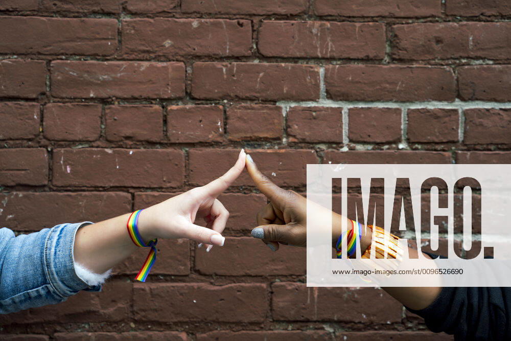 IMAGO Creative: Pride Month 2022, Engagement der Jugendlichen Multiracial gay couple holding hands in Brooklyn New York, United States CR_IGMA191205-248754-01