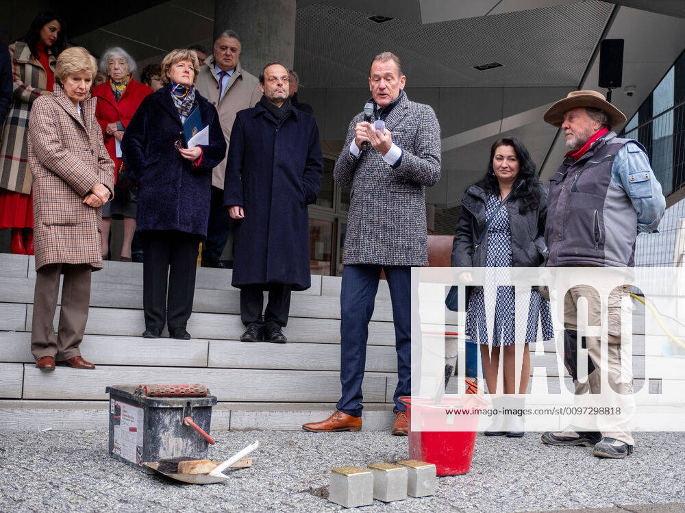 Vor dem neuen Gebaeude des Axel Springer Verlages in Berlin sind am Mittwoch (26.02.2020) die ersten von insgesamt 80 Stolpersteinen verlegt worden. An der Gedenkveranstaltung nahmen neben dem Springer-Vorstandsvorsitzenden Mathias Doepfner (3.v.re.) auch der Antisemitismusbeauftragte der Bundesregierung, Felix Klein (M.), Kulturstaatsministerin Monika Gruetters (CDU, 2.v.li.) und die Holocaust-Ueberlebende Margot Friedlaender (hinten 2.v.li.) teil. (Foto li.: Friede Springer, Verlegerin und Vorstandsmitglied der Axel Springer SE) Verlegt wurden die Stolpersteine vom Initiator des Gedenkprojektes, dem Koelner Kuenstler Gunter Demnig (re. mit Ehefrau). Mit den Stolpersteinen wird an Menschen erinnert, die zwischen 1933 und 1945 von den Nationalsozialisten verfolgt wurden. Die Betonquader mit einer Messingplatte werden in den Gehweg vor