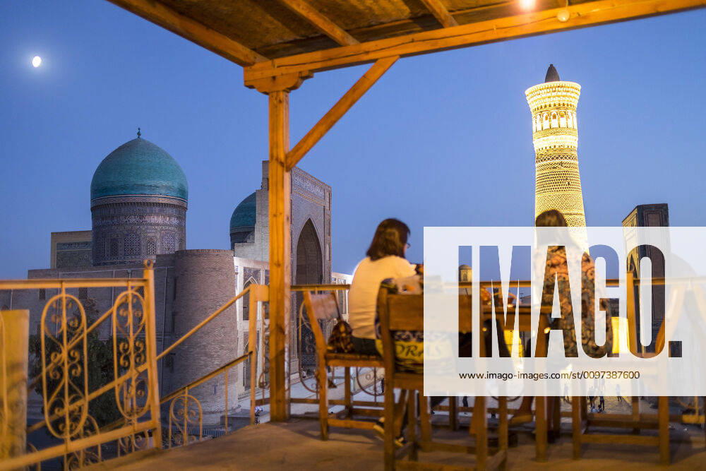 IMAGO Creative: Urbane Kultur - Sommer auf den Dächern Minor Cafe House. At right Kalon minaret and mosque. At left Mir-i-Arab medressa , Bukhara, Uzbekistan Bukhara Uzbekistan