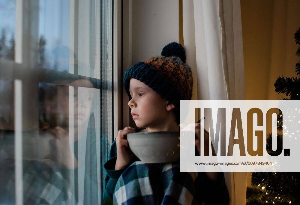 IMAGO Creative: Veganuary, fleischlos leben IMAGO Creative: Kimawandel - Weihnachten, Weihnachtsessen vegan young boy sat on a window sill with a cereal bowl looking outside Norrto¤lje, Stockholm County, Sweden ,model released, Symbolfoto CR_RABE200115-269069-01