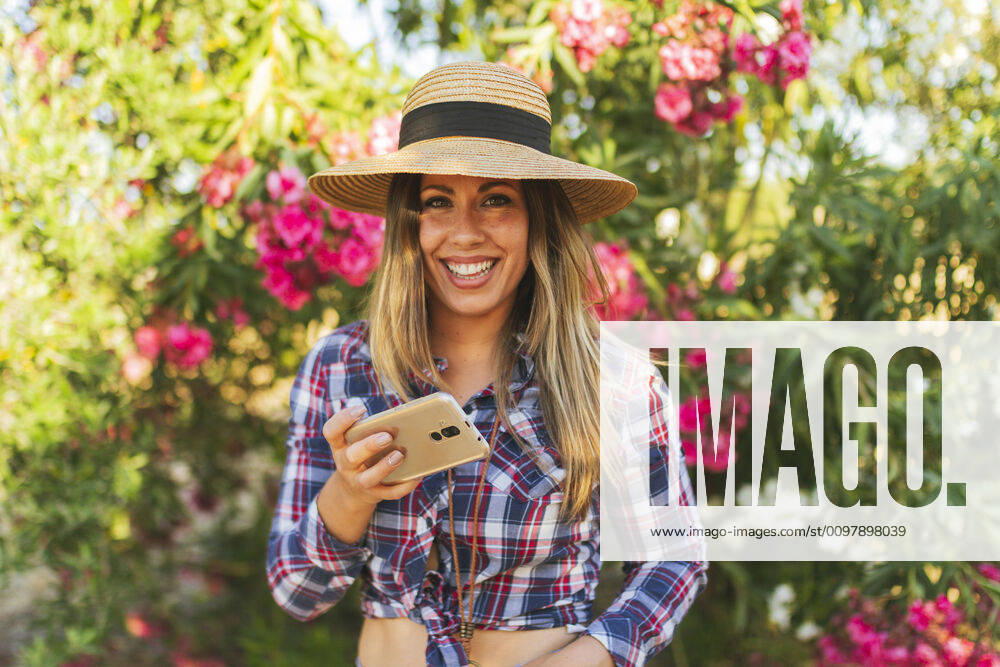 Portrait of young woman with telephone in her hand dressed in checkere Seville, AL, Spain ,model released, Symbolfoto CR_FAGU200128-291721-01