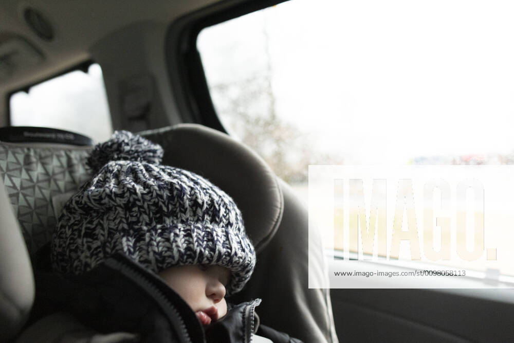 Toddler wearing winter hat sleeps while in carseat inside minivan New York, NY, United States ,model released, Symbolfoto CR_ACZQ200214-309665-01