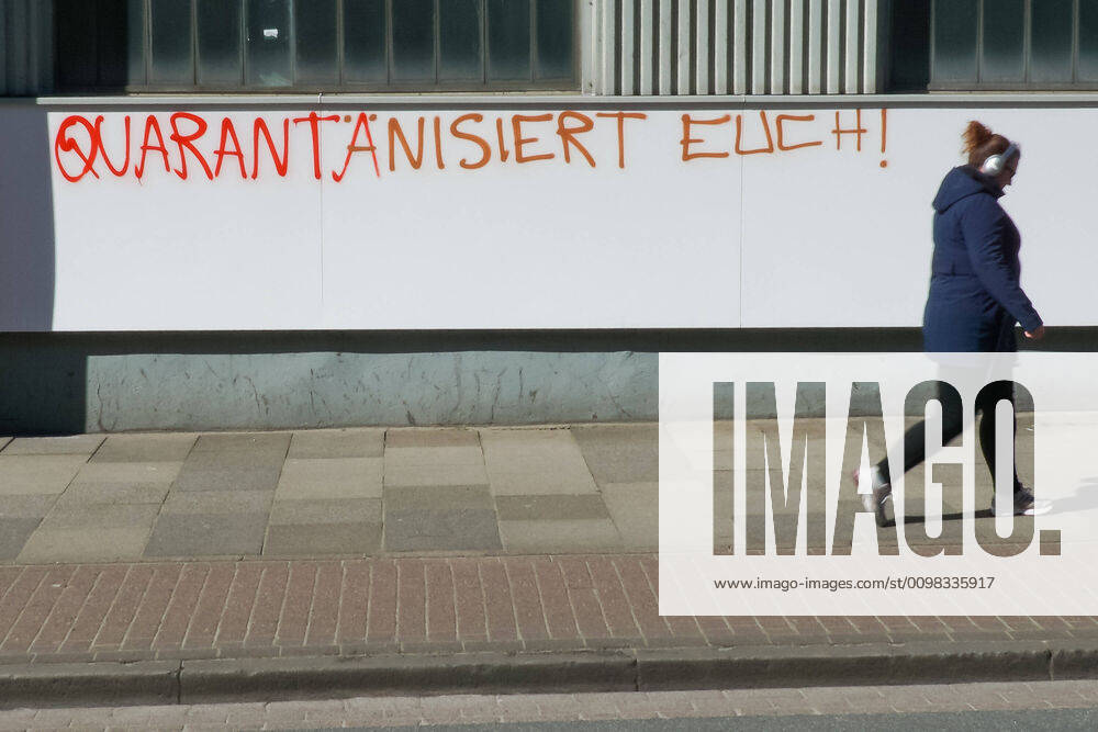 Zur Eindämmung des Coronavirus wurden Geschäftsschließungen angeordnet und werden Ausgangssperren diskutiert, das Foto zeigt eine Fußgängerin vor einem Graffiti, Schriftzug an einem gebäude mit der Aufschrift: Quarantänisiert Euch, 22.03.2020, Bremen (Deutschland), News, Feature, Coronavirus Bremen