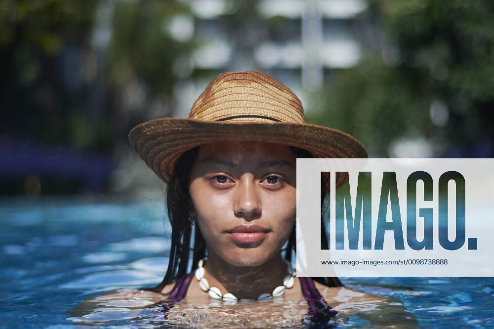 IMAGO Creative, Jahreszeit Sommer, Sonnenschutz Stylish trendy young teen visco girl in the pool wearing a straw hat Denpasar, Bali, Indonesia ,model released, Symbolfoto CR_SAAL200302A-313907-01