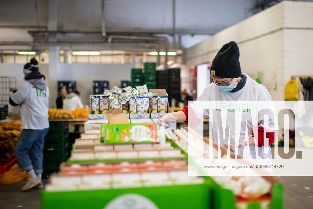 Berlin Corona-Krise Berliner Tafel Auswirkungen der Corona-Krise. Die Corona-Situation hat auch fuer die Hilfsorganisation Berliner Tafel weitreichende Konsequenzen. 42 LAIB und SEELE-Ausgabestellen mussten schliessen, nur drei der Ausgabestellen haben noch geoeffnet. Rund 50.000 beduerftige Menschen kommen ueblicherweise jeden Monat an den Ausgabestellen. Damit die Menschen weiterhin gespendete Lebensmittel erhalten koennen, beliefert die Berliner Tafel nun die Menschen zu Hause. In einer Halle auf dem Berliner Grossmarkt packen freiwillige Helferinnen und Helfer Tueten mit Lebensmitteln (im Bild), die verteilt werden. In einigen Bezirken uebernehmen Radfahrerinnen und Radfahrer der Rebel Riders mit Lastenraedern die Vor-Ort-Verteilung von Tuer zu Tuer. LAIB und SEELE ist eine Aktion der Berliner Tafel e.V., der Kirchen u