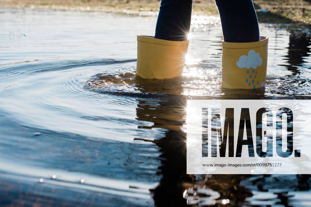Kids rain boots in a big puddle of water at sunset Norrto¤lje, Stockholm County, Sweden ,model released, Symbolfoto CR_RABE200320-317752-01