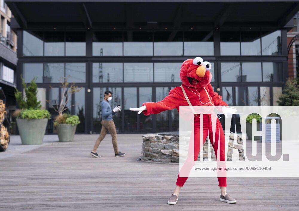 A YouTube performer known as Elmo at the Wharf dances on the Wharf in Washington, D.C. during the Coronavirus pandemic and stay at home order, on Tuesday, April 7, 2020. The performer said she was attempting to bring smiles and joy to the people in the apartment buildings that overlook the area. WAP20200407301 KEVINxDIETSCH