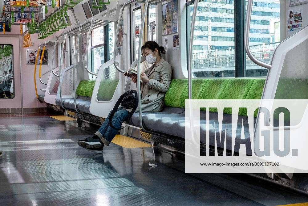 A woman wearing a face mask for protection reads on a almost empty JR train..The Japan government declared a state of emergency to cover Tokyo, Osaka, also covers Saitama, Kanagawa, Chiba, Hyogo and Fukuoka prefectures on the 7th April and will continue until at least May 6. Tokyo governor Yuriko Koike has asked residents to self-isolate as COVID-19 coronavirus spreads. Tokyo Japan - ZUMAs197 20200409_zaa_s197_073
