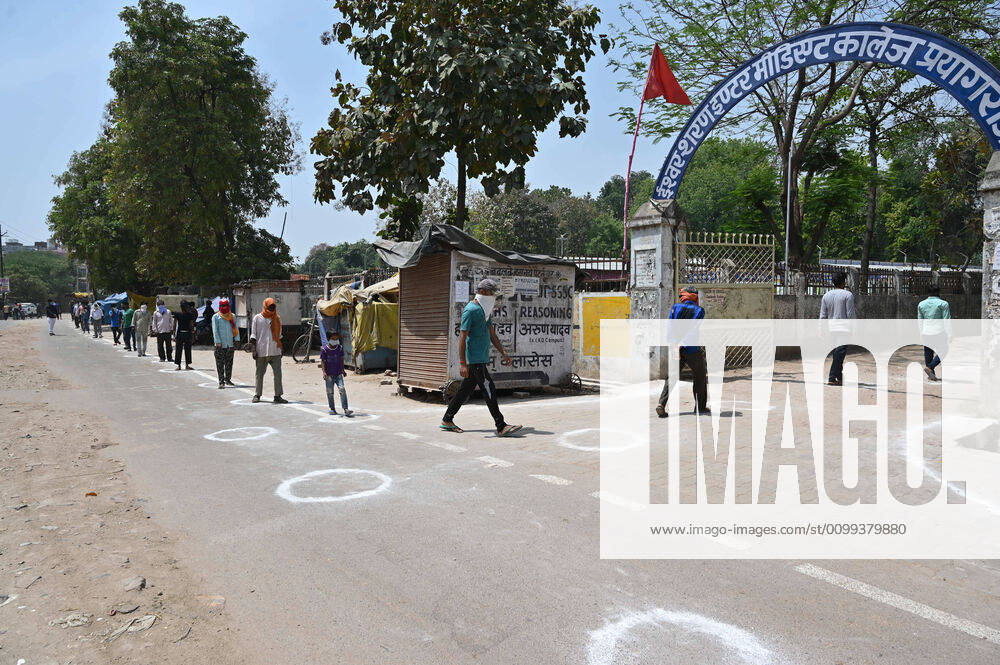 Prayagraj: Migratory workers and students maintain social distance as they in queue to take free food outside Ishwar Sharan college community kitchen during a nationwide lockdown government-imposed nationwide lockdown as a preventive measure against the COVID-19 coronavirus, in Allahabad on Tuesday, April 14, 2020. Prayagraj India - ZUMAv115 20200414_zap_v115_008