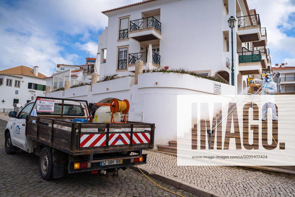 An employee of the Ericeira parish council, equipped with the recommended protective materials, disinfects the street with a solution based on hypochlorite (bleach)..The municipality of Mafra had 70 cases of COVID-19 pandemic. In order to prevent the spread of the virus, the Ericeira Parish Council perform weekly street disinfection. Ericeira Portugal - ZUMAs197 20200414_zaa_s197_173