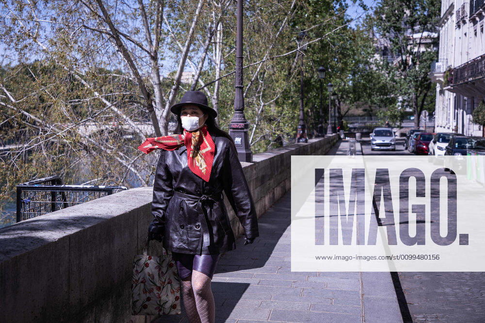A woman wearing a face mask as a preventive measure from coronavirus, walks on the banks of the Seine in Paris during the quarantine..France has recorded 112606 confirmed cases, 36578 recovered and 19718 deaths by the corona virus. Paris France - ZUMAs197 20200414_zaa_s197_197