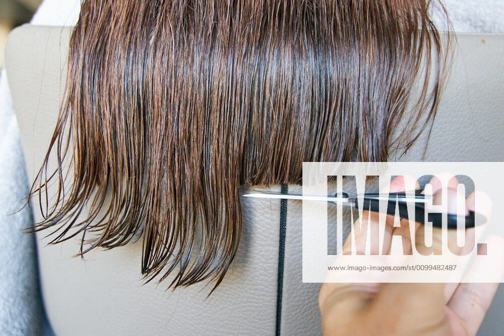 Pfaffenhofen a.d.Ilm, Germany, April 20, 2020. A woman cuts her hair herself on April 20, 2020 in Pfaffenhofen a.d.Ilm, Bavaria, Germany. Due to Corona virus, hair stylists were shut down for many weeks and will open up again soon.