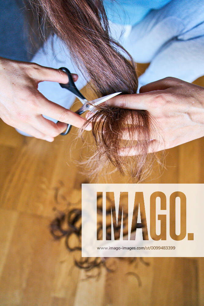 Pfaffenhofen a.d.Ilm, Germany, April 20, 2020. A woman cuts her hair herself on April 20, 2020 in Pfaffenhofen a.d.Ilm, Bavaria, Germany. Due to Corona virus, hair stylists were shut down for many weeks and will open up again soon.