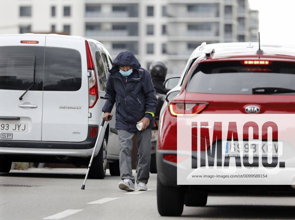 A homeless, protected with a mask, begs among the cars stopped at Cerda square in Barcelona, Spain, 22 April 2020. Spain is under a lockdown to avoid the spreading of pandemic of the COVID-19 disease caused by the SARS-CoV-2 coronavirus. Daily life during lockdown !ACHTUNG: NUR REDAKTIONELLE NUTZUNG!