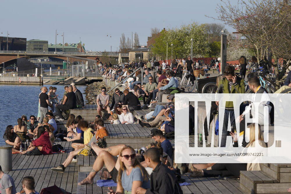 Koebenhavnere nyder det varme foraarsvejr paa Island Brygge i Koebenhavn torsdag den 23. april 2020. ** OBS billedet et optaget med et teleobjektiv og afstanden mellem personer paa billedet kan opfattes mindre en den reelt er. **. , Copenhagen Denmark