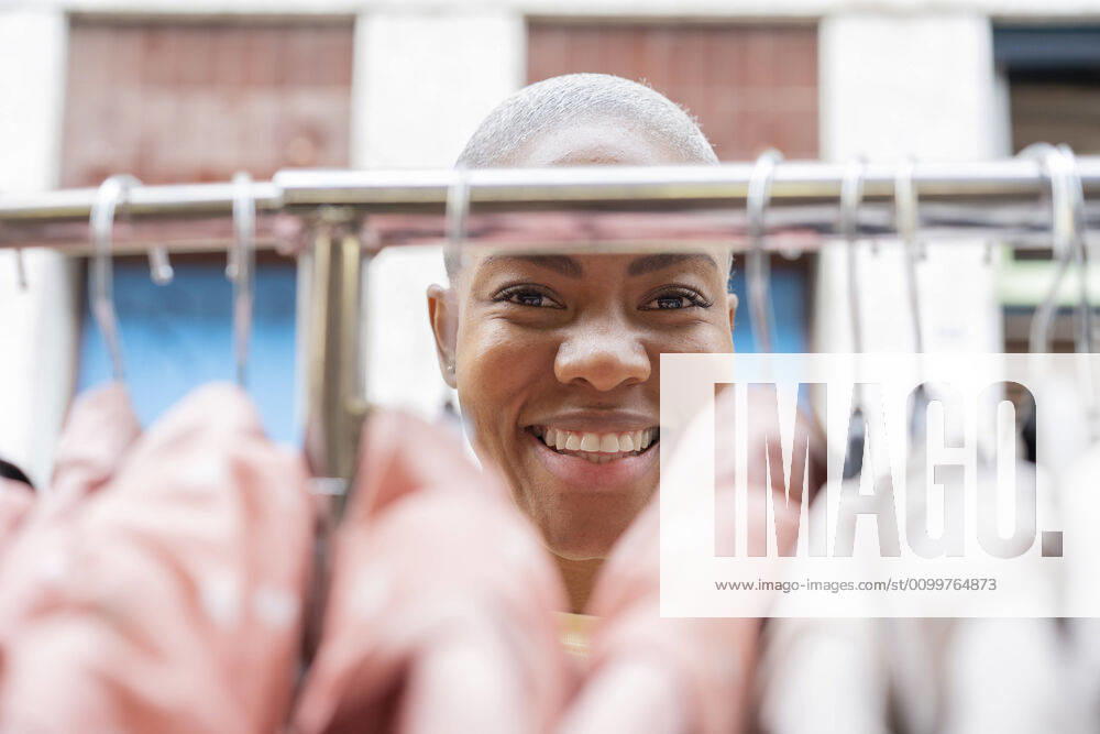 Portrait of happy woman behind clothes rail model released Symbolfoto AFVF05917