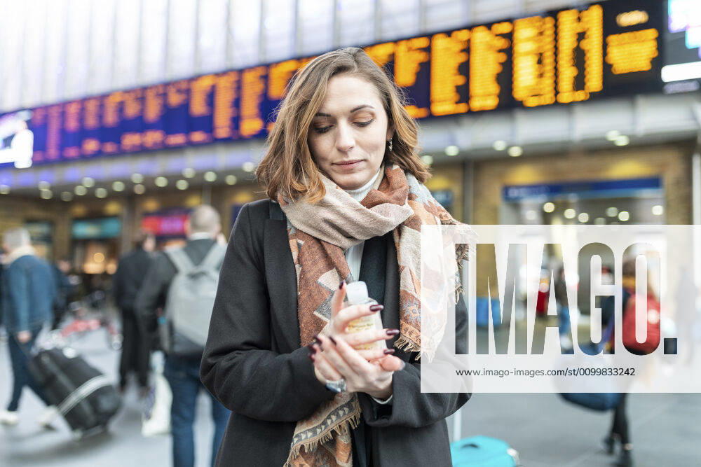 Woman using sanitising hand gel at train station model released Symbolfoto WPEF02798