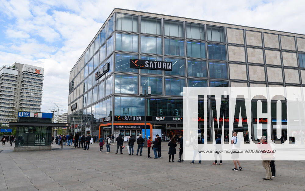 Warteschlange vor dem Saturn am Berliner Alexanderplatz Seit Mittwoch den 22.04. können Verbraucher in Berlin auch in zahlreichen Geschäften jenseits des Lebensmittelhandels wieder einkaufen. Die Regelung gilt für Läden mit einer Verkaufsfläche von bis zu 800 Quadratmetern. Auch Kauf- und Warenhäuser dürfen öffnen, solange sie mit einer entsprechend verkleinerten Verkaufsfläche öffnen. Hier im Bild stehen die Menschen Schlange, um in den Saturn am Alexanderplatz zu gelangen., Berlin Berlin Deutschland Kreuzberg