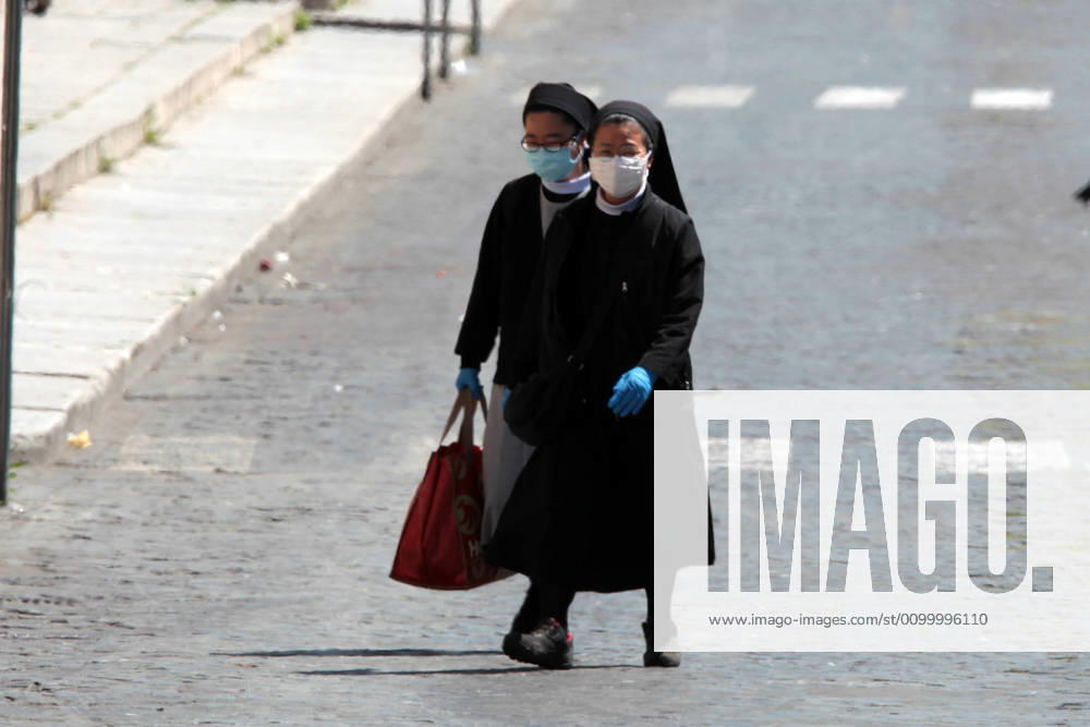 Italy: Pope Francis blessing Two nunes wearing a mask crossing the empty St.Peter s square due to the national lock down as it battels against the spread of the new coronavirus dubbed COVID-19 Vatican city Vatican City Italy