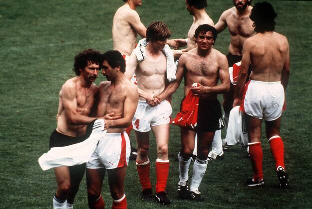 IMAGO Iconic Moments, Fußball Trikottausch der Akteure nach dem Skandalspiel von Gijon - v. li.: Paul Breitner (Deutschland), Hans Krankl, Josef Degeorgi (beide Österreich) und Felix Magath Fußball WM Herren Weltmeisterschaft 1982, Länderspiel, Gruppenspiel, Gruppe 2, Nationalmannschaft, Nationalteam Gruppe Spielabsprache, unsportlich, Unsportlichkeit
