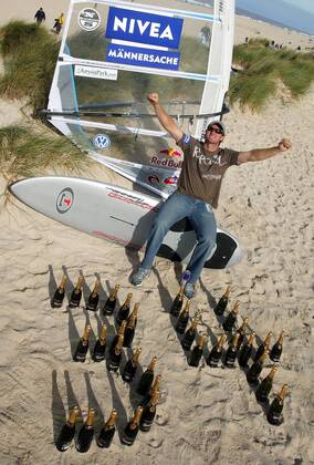 Björn Dunkerbeck ist 34maliger Weltmeister und fühlt sich wie ein junger Gott - Um seine einmalige Bilanz zu visualisieren, hat er die Zahl 34 mal aus ebenso vielen Sektflaschen im Sand gebaut und Männersache ist der Surfsport laut Sponsor Nivea sowieso Surfen Herren PWA Tour 2005, Nivea Worldcup, Weltcup, Welt Cup, World, WC, Surfing, Windsurfing, Windsurfen Einzelbild Sponsor, Sponsoring, Werbepartner, Werbung Westerland Sylt Schriftzug, Kosmetik Freude,