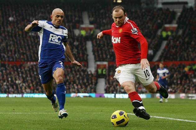 Football - Premier League - Manchester United vs. Birmingham City Stephen Carr of Birmingham City (L) chases down Wayne Rooney of Manchester United at Old Trafford