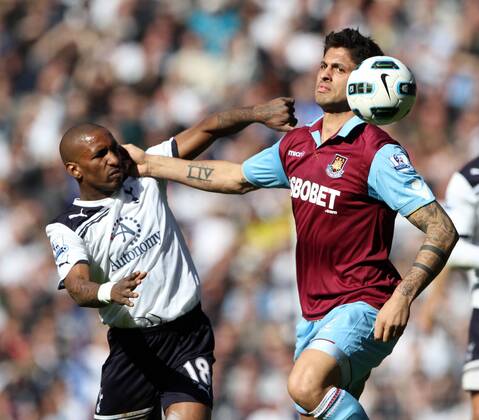 Tottenhams Jermain Defoe tussles with West Hams Manuel Da Costa --- Tottenham Hotspur (white) vs. West Ham United (red) EDITORIAL USE ONLY. No use with unauthorised audio, video, data, fixture lists, club league logos or live services. Online in-match use limited to 120 images, no video emulation. No use in betting, games or single club league player publications.